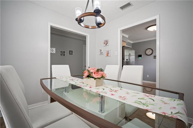 1120 Abilene Dr W, Mobile, AL 36695 - dining area featuring a chandelier, a textured ceiling, and ornamental molding