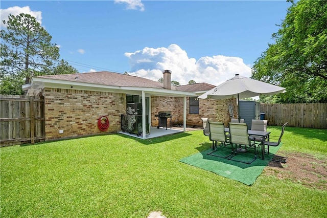 1120 Abilene Dr W, Mobile, AL 36695 - rear view of property featuring brick siding, a patio, a fenced backyard, and a chimney