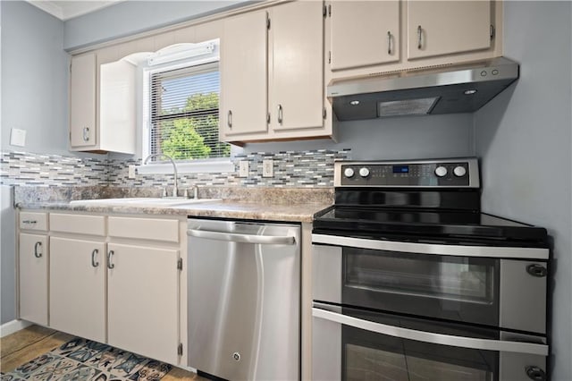 1120 Abilene Dr W, Mobile, AL 36695 - kitchen featuring stainless steel appliances, under cabinet range hood, backsplash, and light countertops