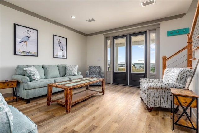 living room with ornamental molding and light wood-type flooring