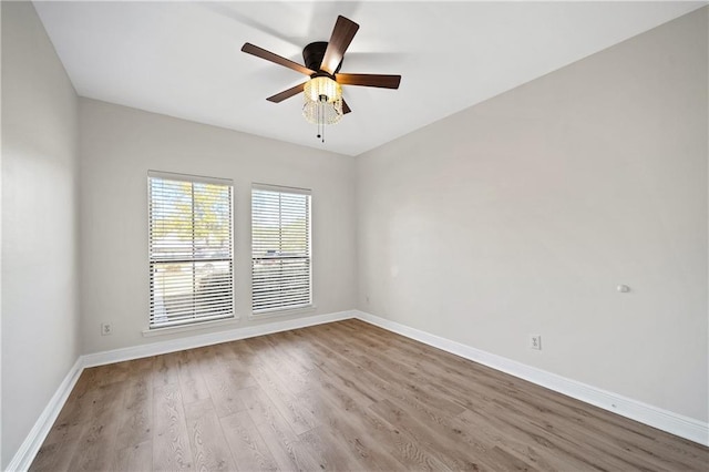 unfurnished room with ceiling fan, baseboards, and wood finished floors