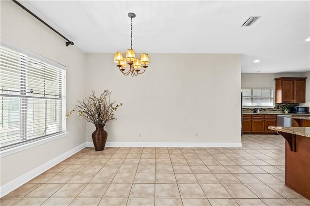 dining area featuring a healthy amount of sunlight, visible vents, baseboards, and an inviting chandelier