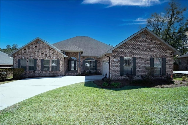 single story home featuring brick siding, roof with shingles, an attached garage, a front yard, and driveway