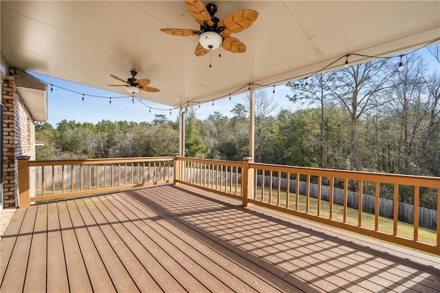 wooden deck featuring a yard, fence, and a ceiling fan