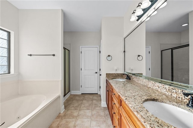 bathroom featuring a garden tub, a stall shower, a sink, and tile patterned floors