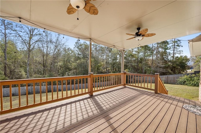 wooden terrace with ceiling fan, a yard, and a fenced backyard