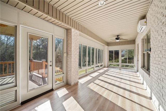 unfurnished sunroom with a ceiling fan and an AC wall unit