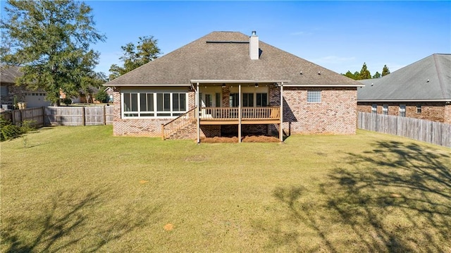 back of property featuring a fenced backyard, a lawn, a chimney, and brick siding