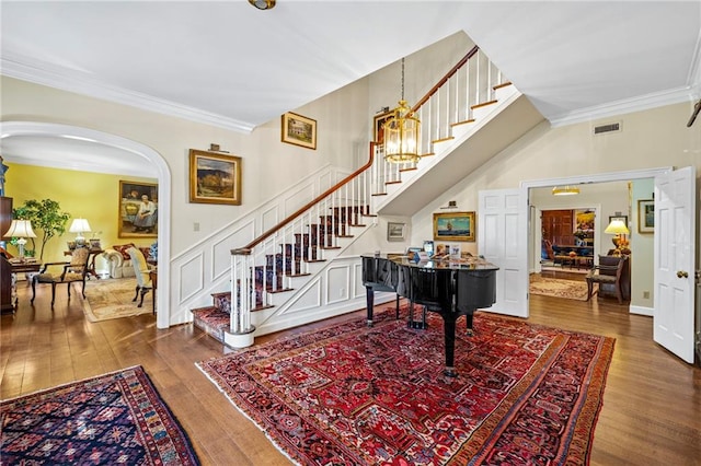 entryway featuring crown molding, hardwood / wood-style flooring, and a notable chandelier