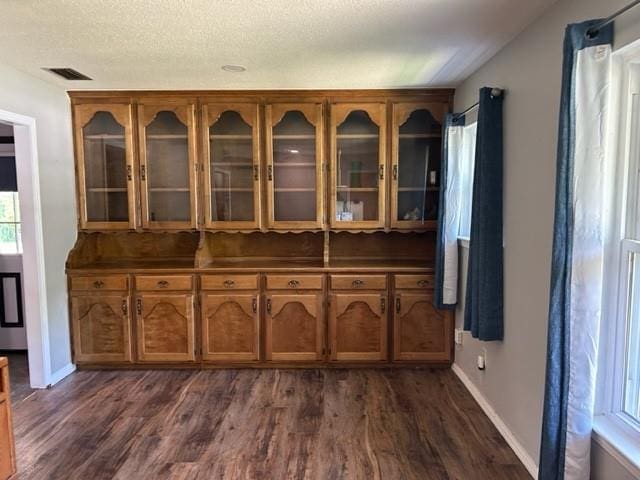 bar with dark hardwood / wood-style floors and a textured ceiling