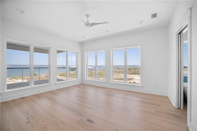 unfurnished sunroom featuring plenty of natural light and a water view
