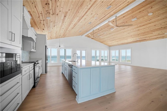 kitchen with stainless steel appliances, a sink, wooden ceiling, open floor plan, and light wood-style flooring