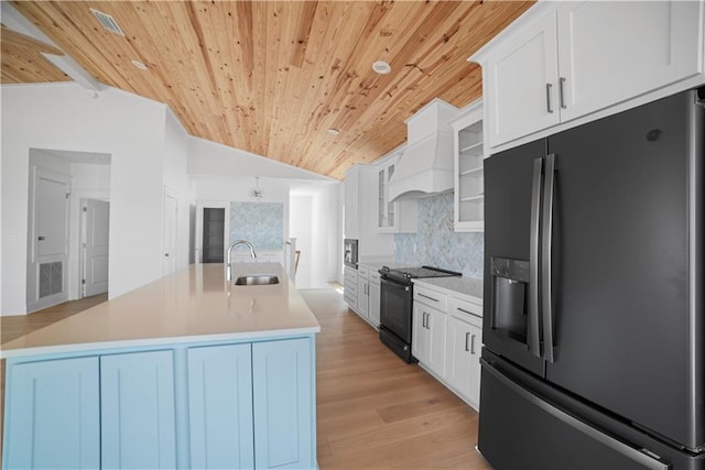 kitchen featuring refrigerator with ice dispenser, black electric range oven, wood ceiling, a sink, and vaulted ceiling