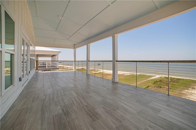 wooden deck featuring view of water and beach