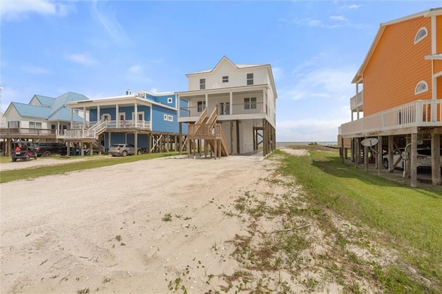 2626 Bridgeview Dr, Dauphin Island, AL 36528 - rear view of property featuring a carport, dirt driveway, and stairway