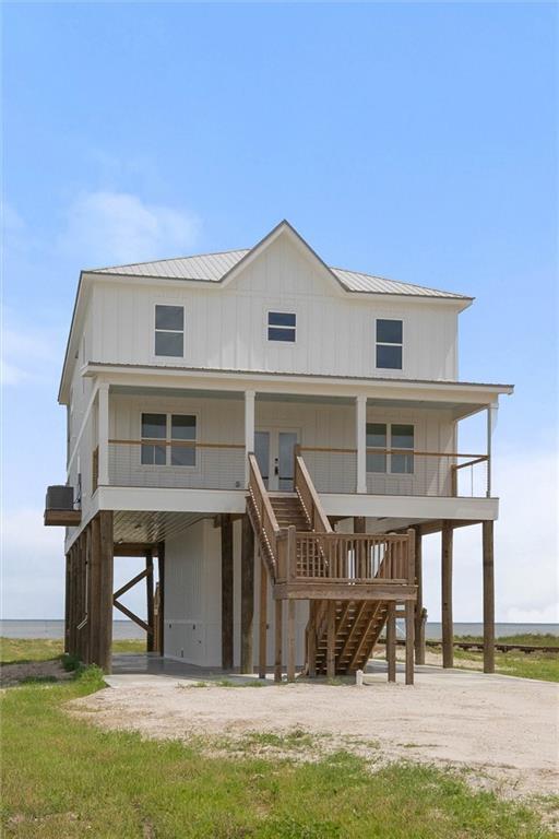 2626 Bridgeview Dr, Dauphin Island, AL 36528 - back of property featuring a carport, stairway, a porch, a metal roof, and concrete driveway