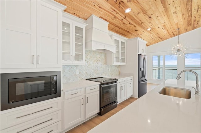 2626 Bridgeview Dr, Dauphin Island, AL 36528 - kitchen featuring electric range, wooden ceiling, black microwave, premium range hood, and light countertops