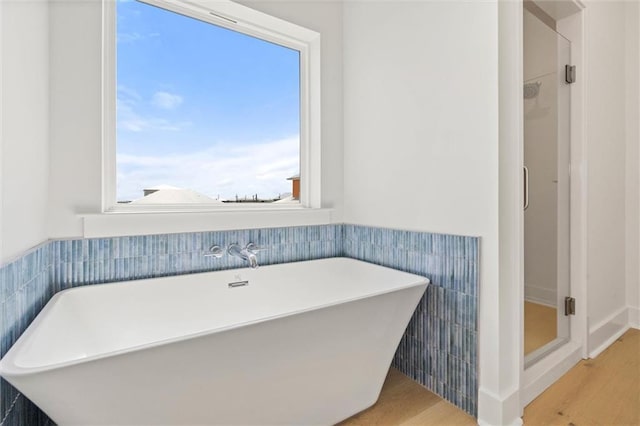 2626 Bridgeview Dr, Dauphin Island, AL 36528 - bathroom with wood finished floors, a freestanding tub, a shower stall, and wainscoting