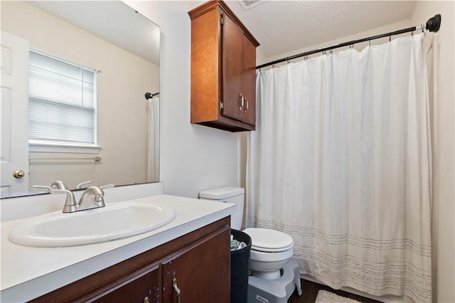 bathroom featuring vanity, toilet, wood-type flooring, and a textured ceiling