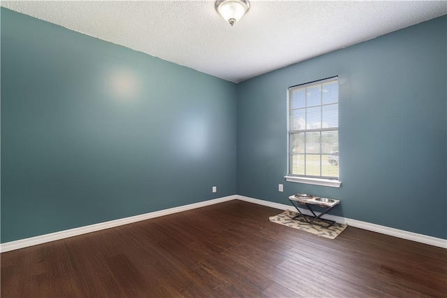 spare room with wood-type flooring and a textured ceiling