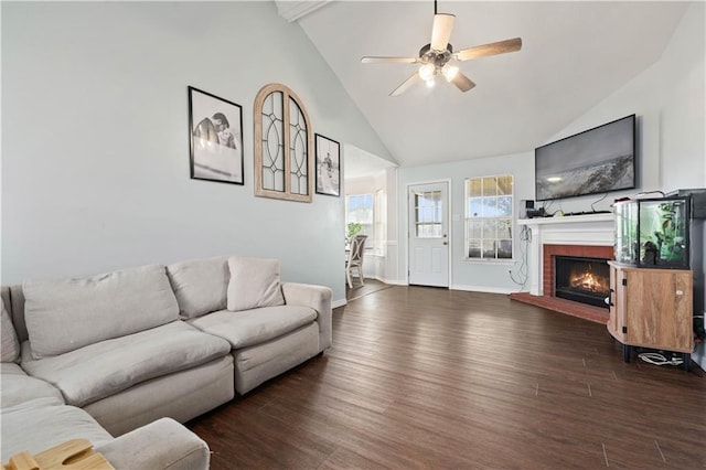 living room with a fireplace, ceiling fan, dark hardwood / wood-style flooring, and vaulted ceiling