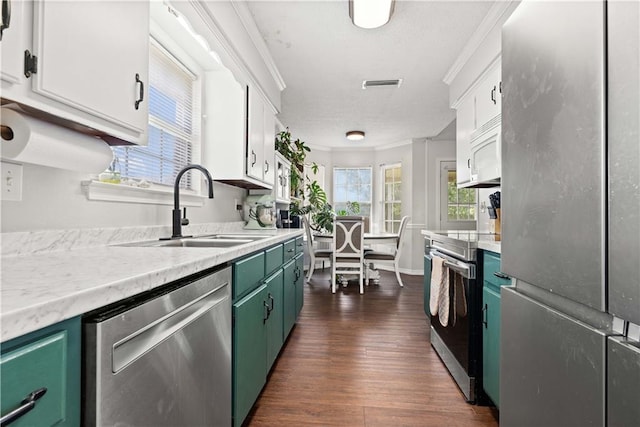 kitchen with crown molding, white cabinets, and stainless steel appliances