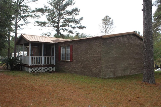 view of property exterior featuring a lawn and a sunroom