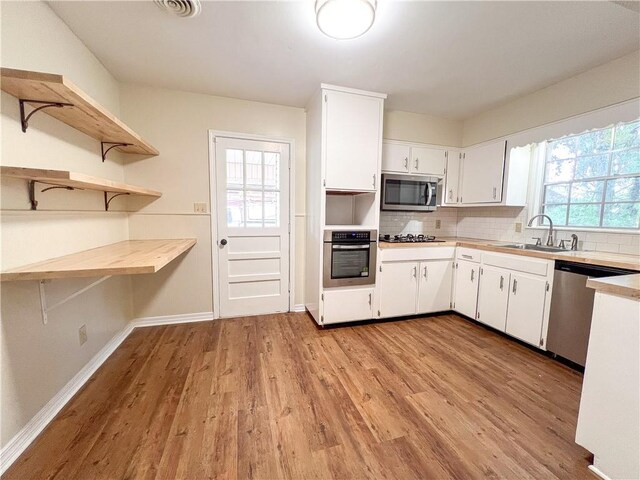 2602 Eldorado Dr, Mobile, AL 36605 - kitchen with appliances with stainless steel finishes, light countertops, a sink, and light wood-style flooring