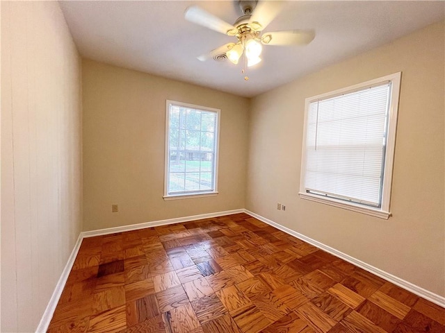 empty room featuring ceiling fan and parquet flooring