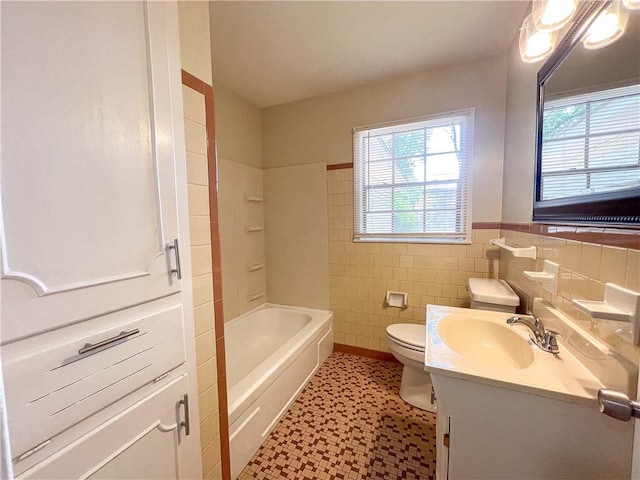 bathroom with vanity, tile walls, and toilet