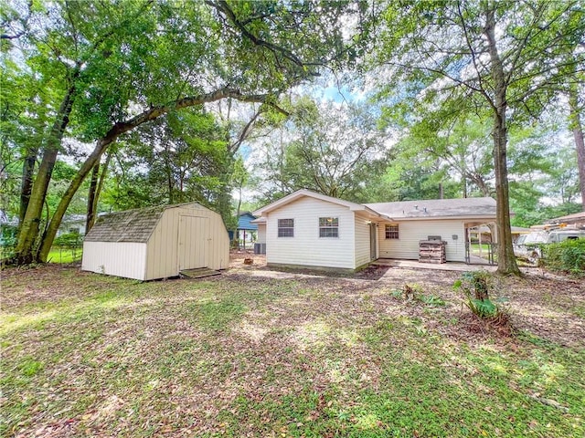 back of house with a storage shed and a patio