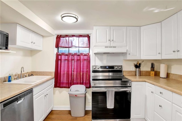 kitchen featuring hardwood / wood-style flooring, stainless steel appliances, sink, and white cabinetry