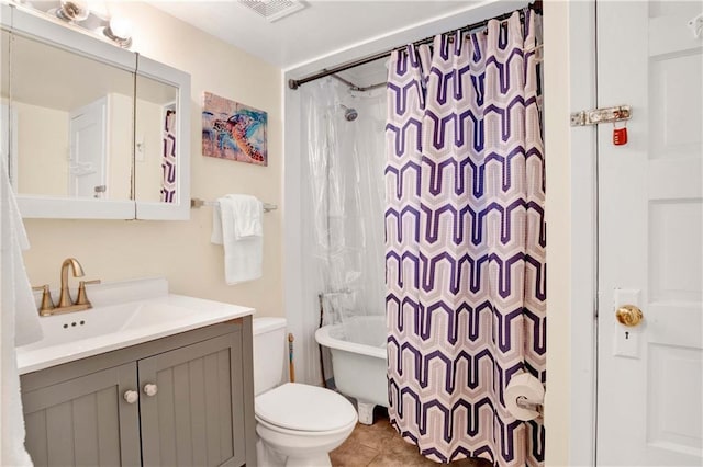 full bathroom with tile patterned floors, vanity, shower / bath combo with shower curtain, and toilet