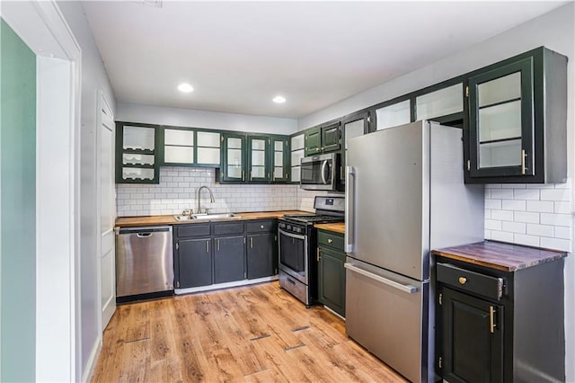 kitchen with sink, tasteful backsplash, light hardwood / wood-style floors, and stainless steel appliances