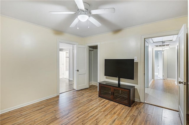 living room with ceiling fan, ornamental molding, and light wood-type flooring