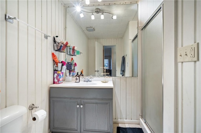 bathroom with vanity, an enclosed shower, and toilet