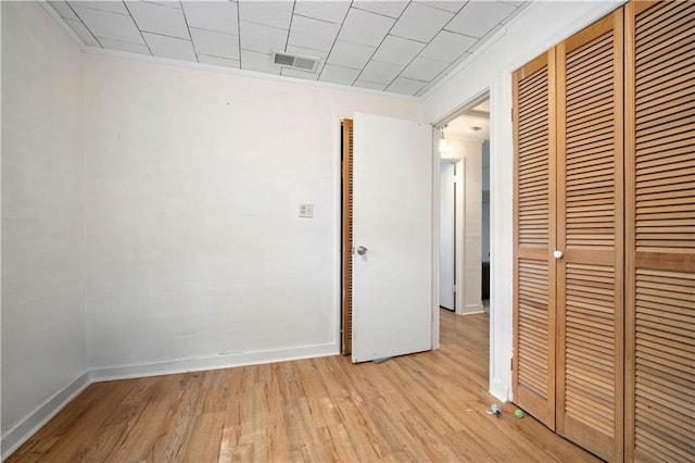 unfurnished bedroom featuring ornamental molding, a closet, and light wood-type flooring