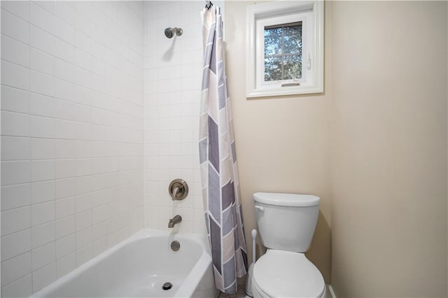 bathroom with shower / bath combination with curtain and toilet