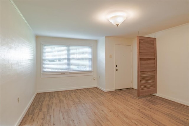 unfurnished room featuring crown molding and light wood-type flooring