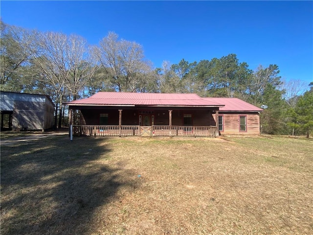 rear view of property featuring metal roof and a yard