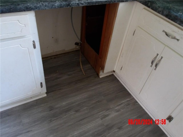 interior space featuring dark wood-type flooring and white cabinets