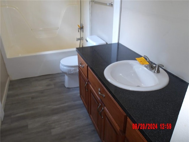 full bathroom with shower / washtub combination, wood-type flooring, vanity, and toilet