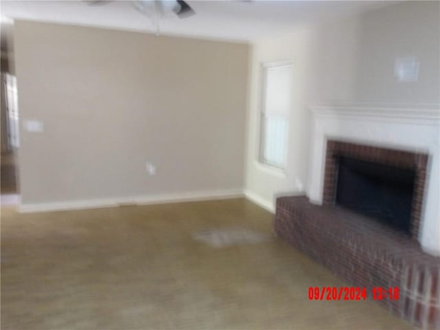 unfurnished living room featuring a brick fireplace and carpet floors