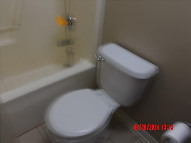 bathroom featuring shower / washtub combination and toilet