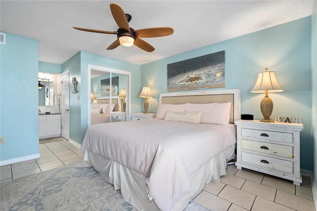 633 Beach Blvd Unit 205, Gulf Shores, AL 36542 - tiled bedroom with a textured ceiling, ceiling fan, ensuite bath, a closet, and baseboards