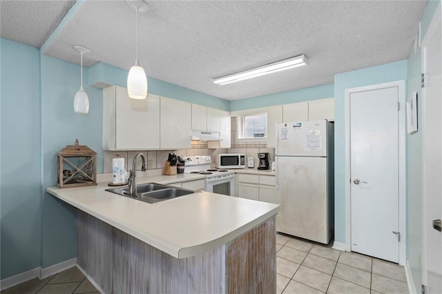 633 Beach Blvd Unit 205, Gulf Shores, AL 36542 - kitchen with white appliances, a sink, under cabinet range hood, a peninsula, and light tile patterned floors