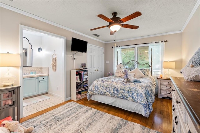 bedroom with a textured ceiling, ceiling fan, dark hardwood / wood-style floors, and ornamental molding