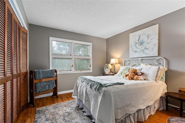 bedroom featuring wood-type flooring, a textured ceiling, and a closet