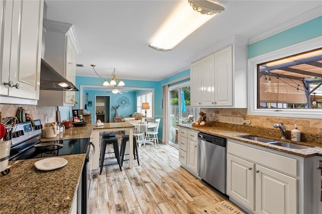 kitchen with stainless steel appliances, light hardwood / wood-style flooring, backsplash, dark stone counters, and white cabinets