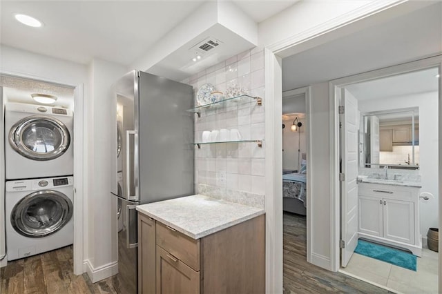 1051 Beach Blvd W Unit 9B, Gulf Shores, AL 36542 - ensuite bathroom featuring stacked washer / drying machine, vanity, wood finished floors, and backsplash
